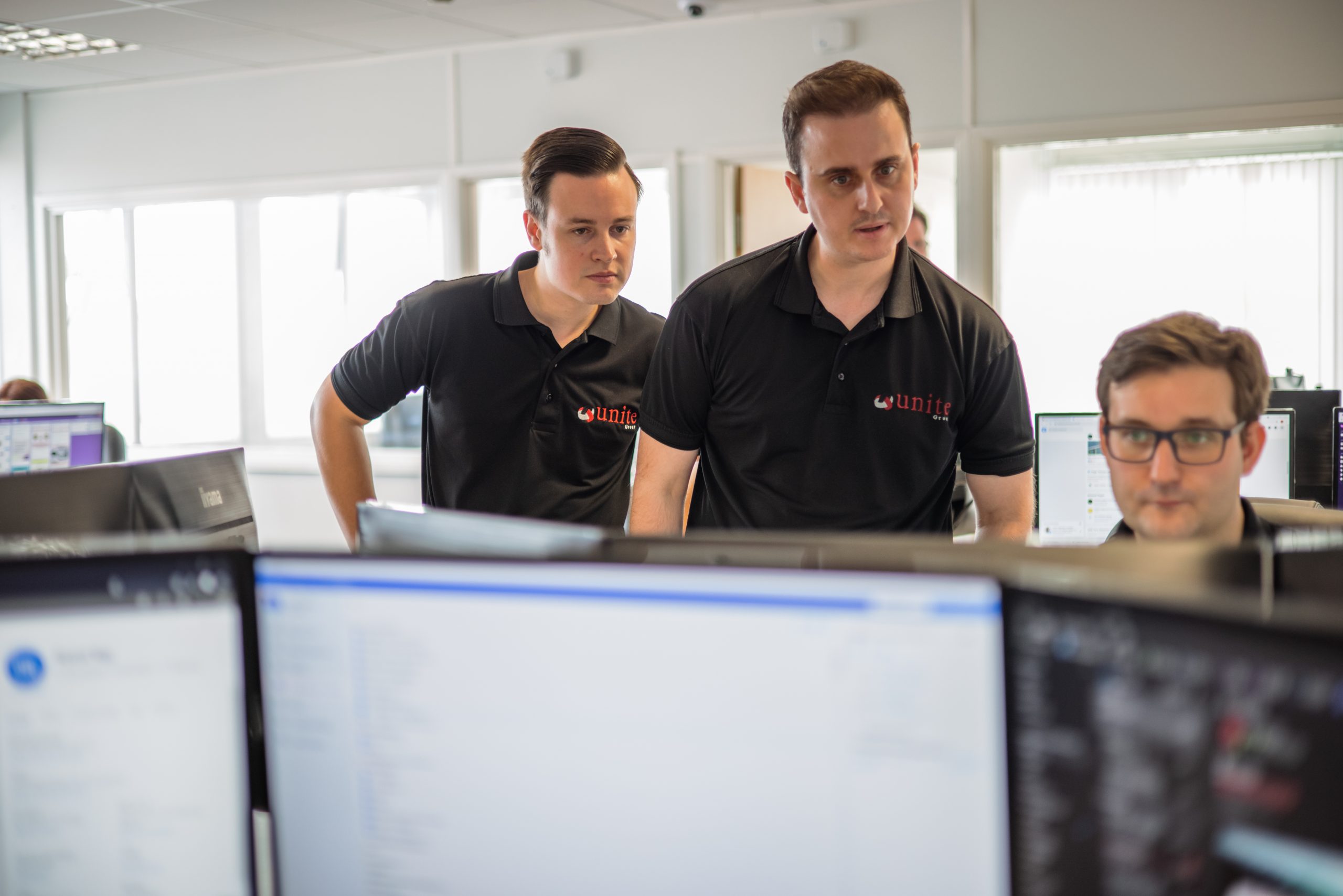 3 team members looking at a computer