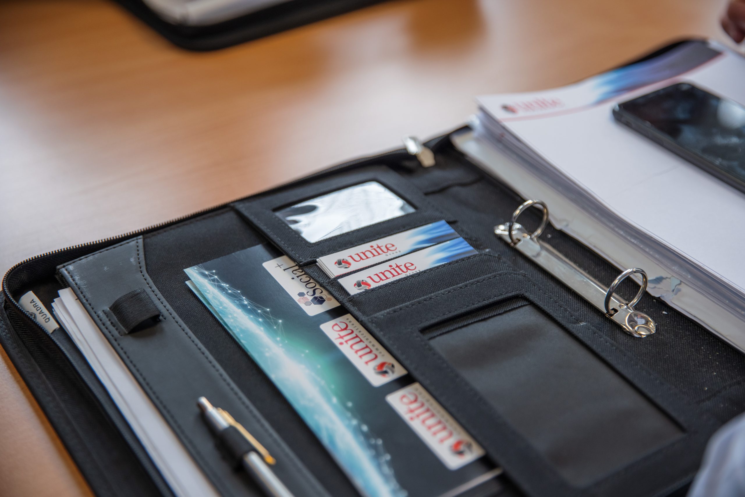 folder with The Unite Group business cards inside