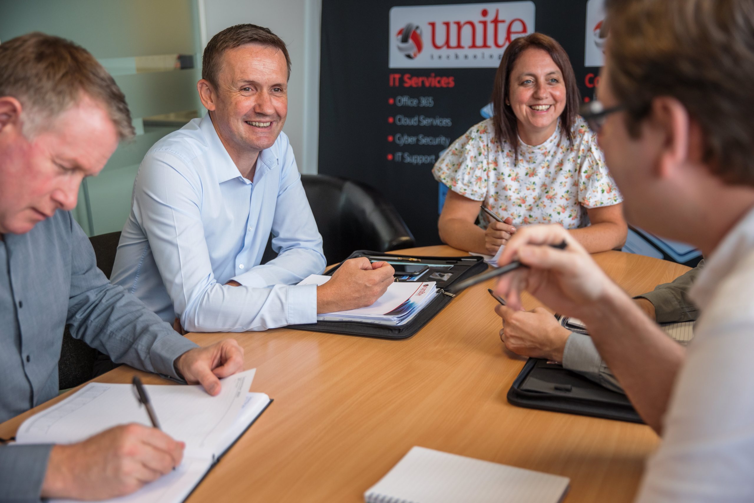 employees of the unite group sat around a table laughing